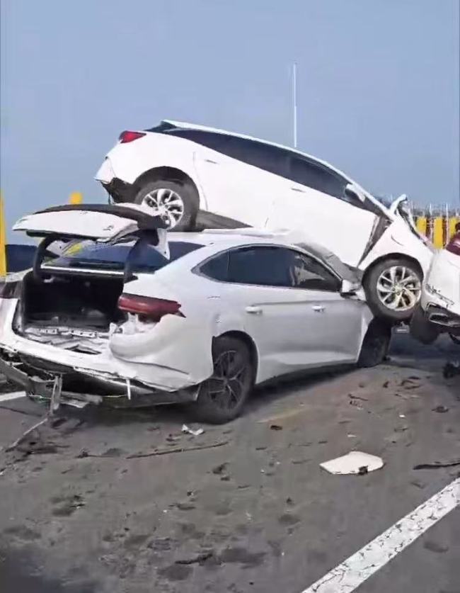 车祸现场白车骑隔离栏将另一车压住 变道引发连环撞