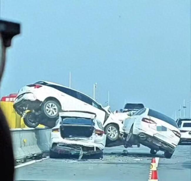 车祸现场白车骑隔离栏将另一车压住 变道引发连环撞